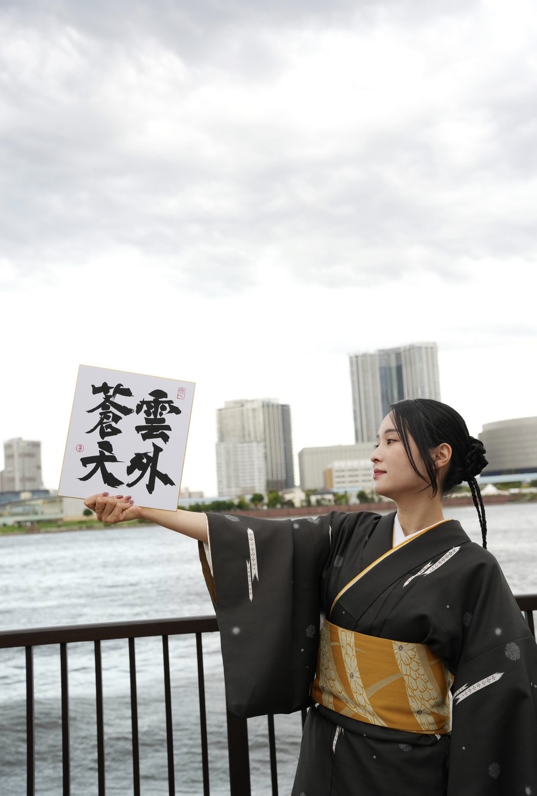 着物姿で書道作品を掲げる講師・凌霄（りょうしょう）